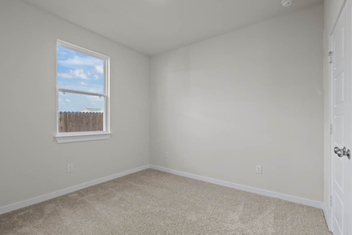 A room with a window and a carpet.