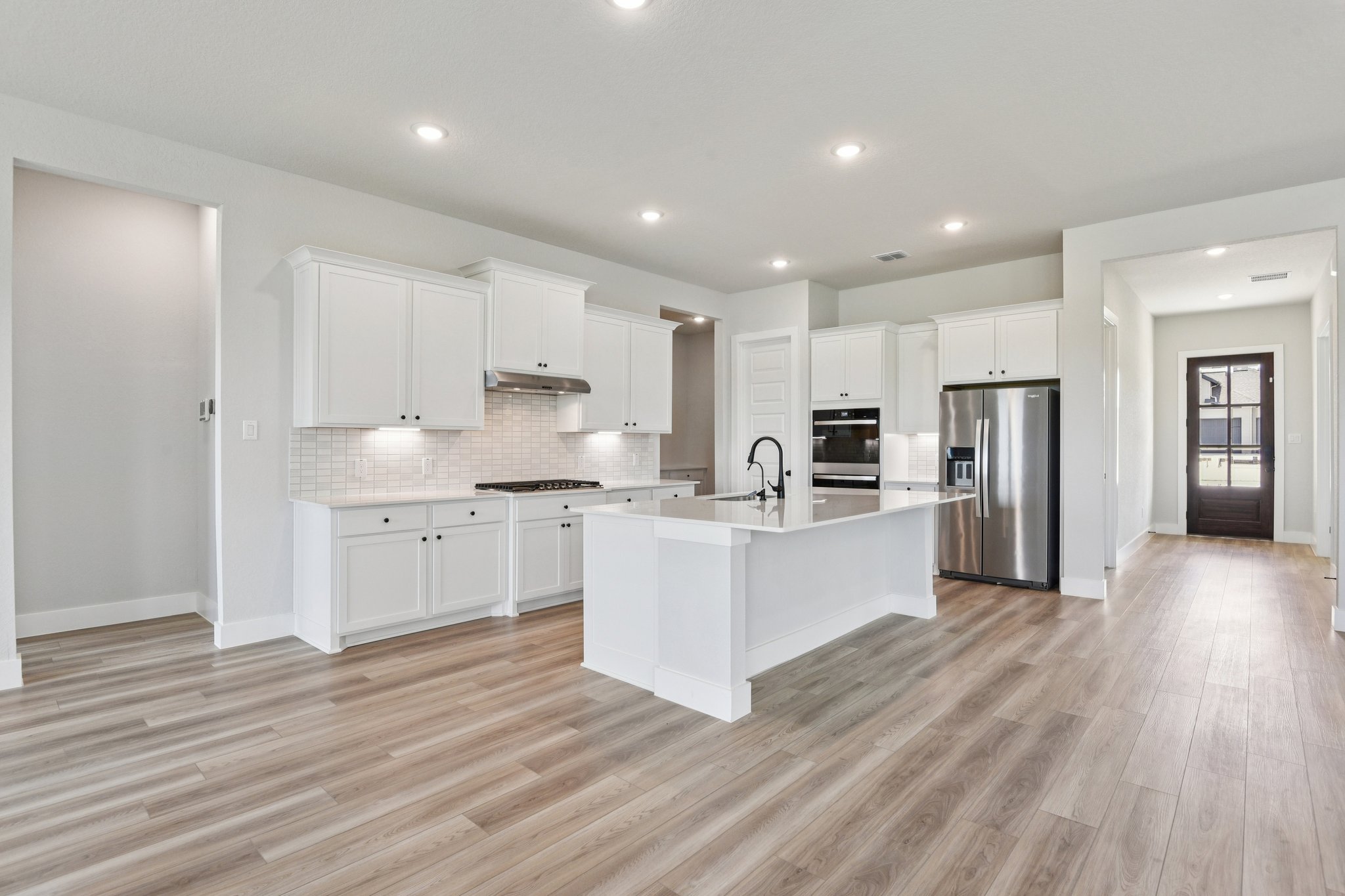 A kitchen with white cabinets.