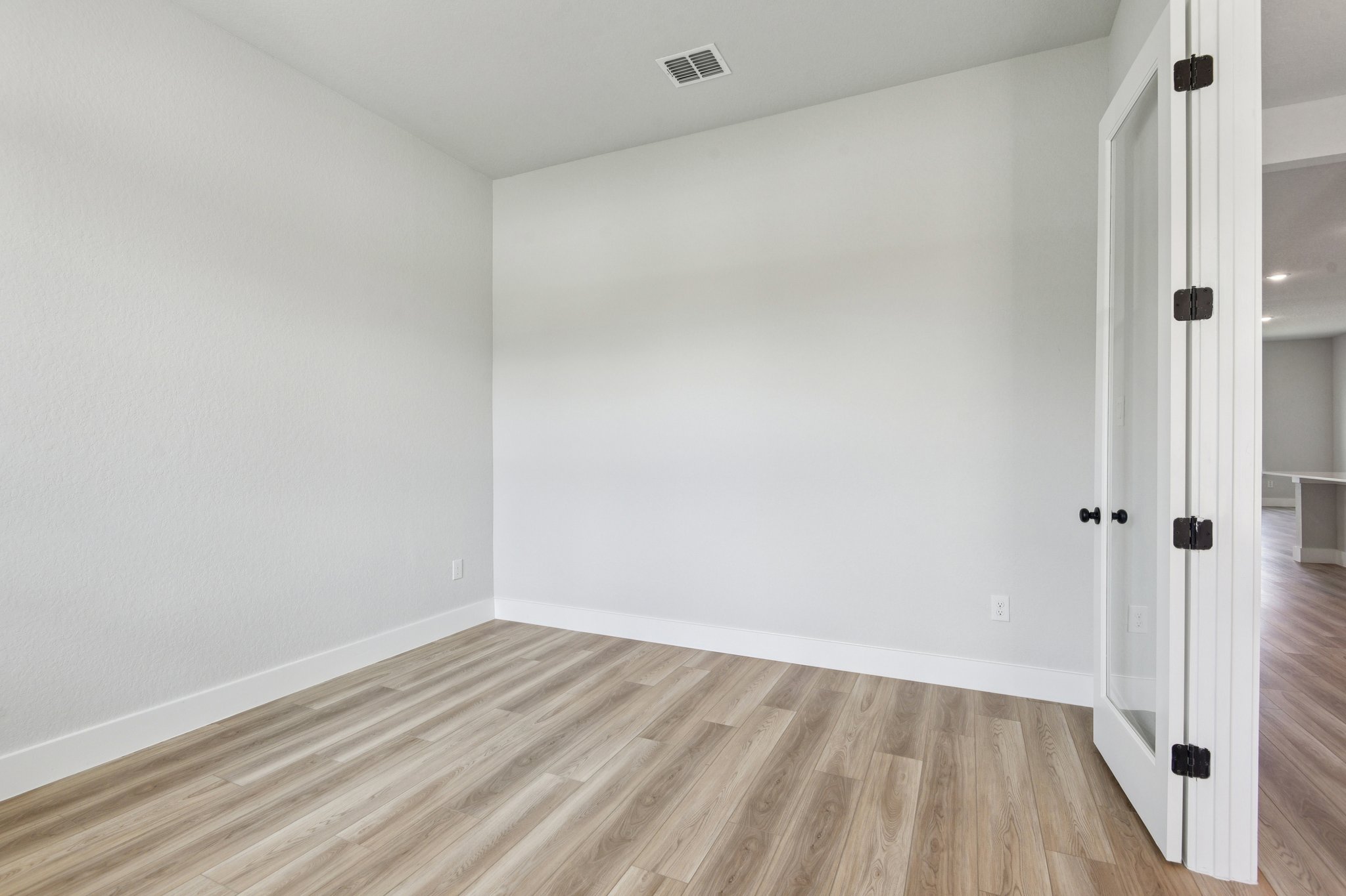 A room with a wood floor and white walls.