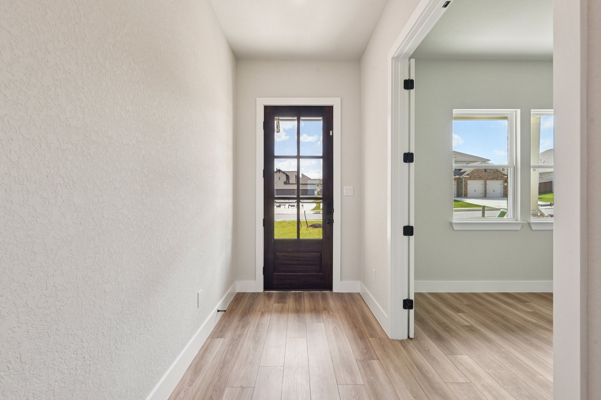 A room with a wood floor and a wood floor with a door.