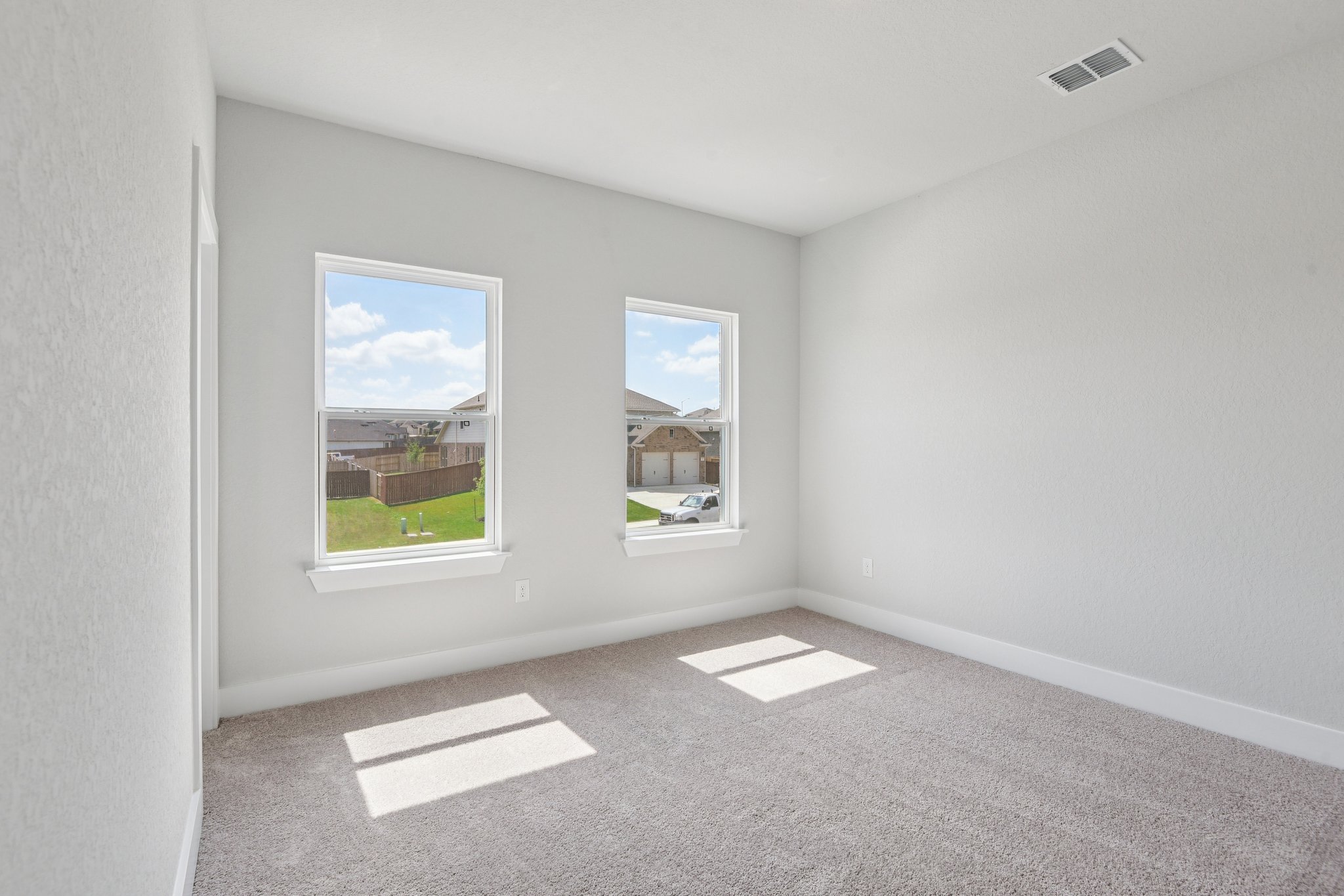 A room with a window and a rug.
