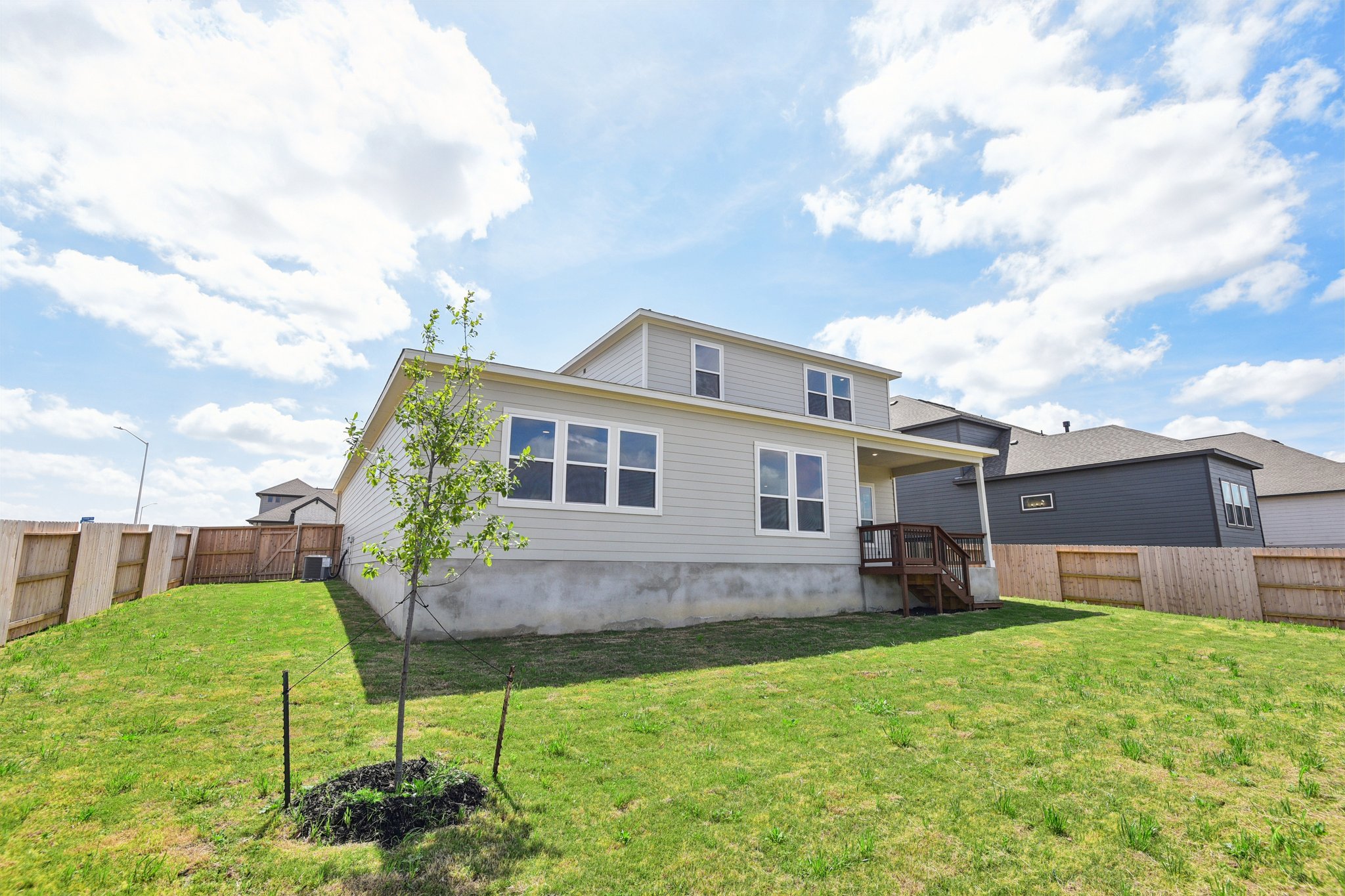 A house with a fence and trees in the front.