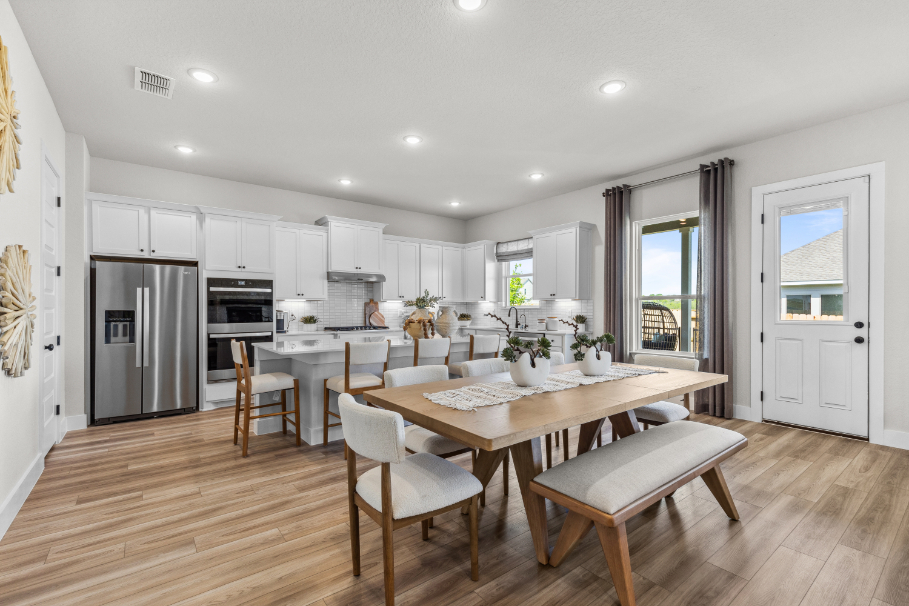 A kitchen with a dining table and chairs.