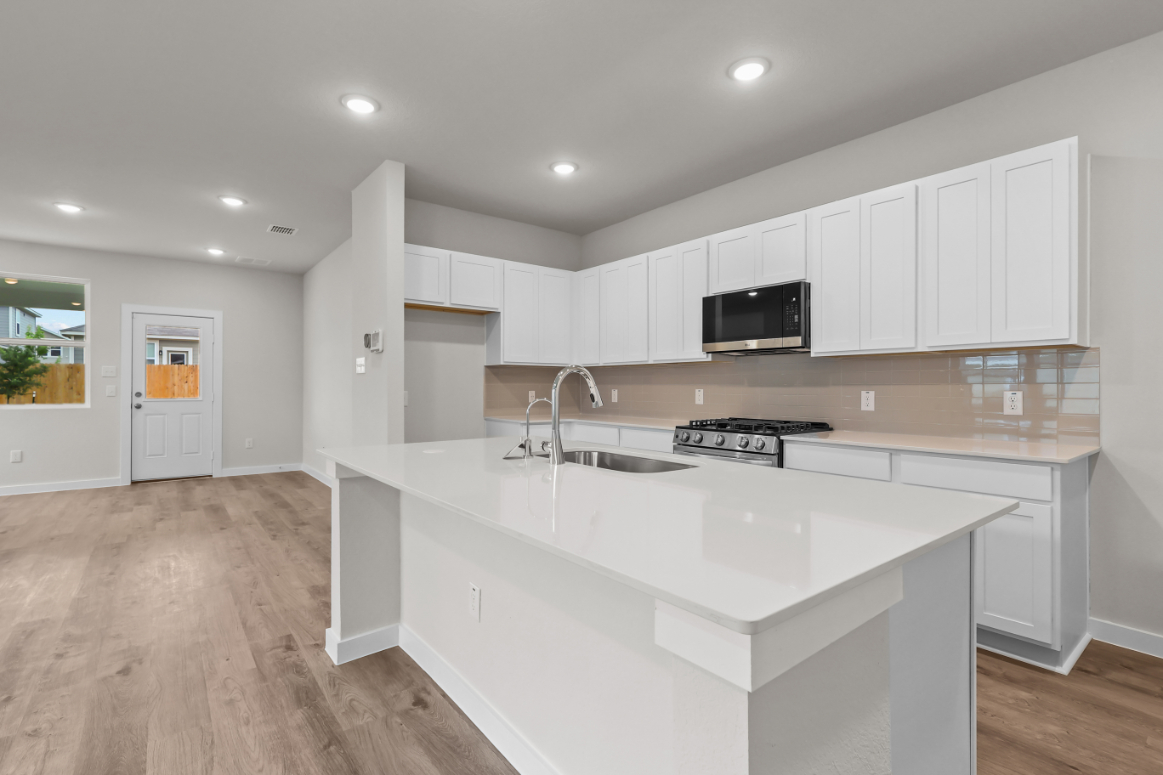 A kitchen with white cabinets.