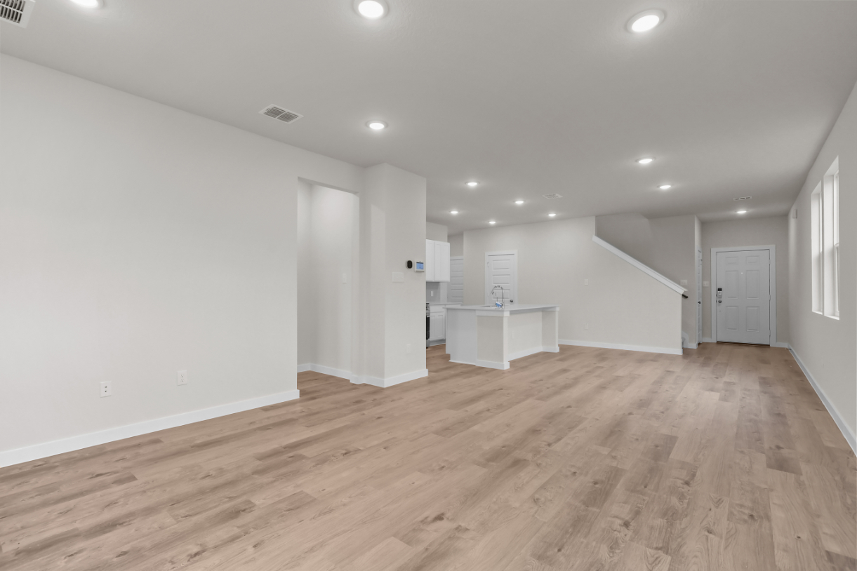A room with white walls and wood floors.