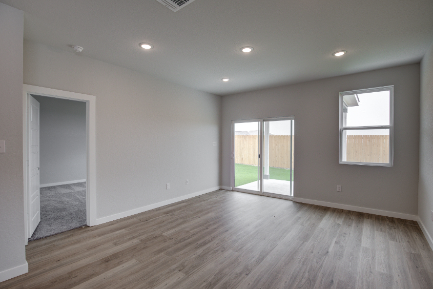 A room with a wood floor and windows.