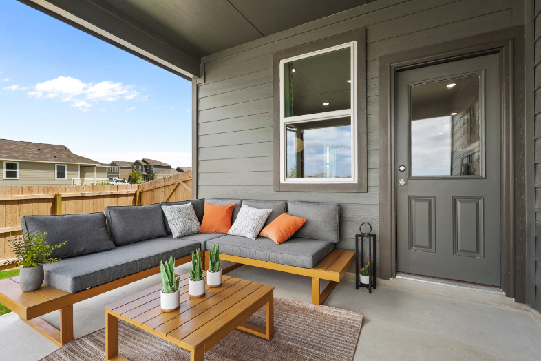 A couch and a table outside a house.