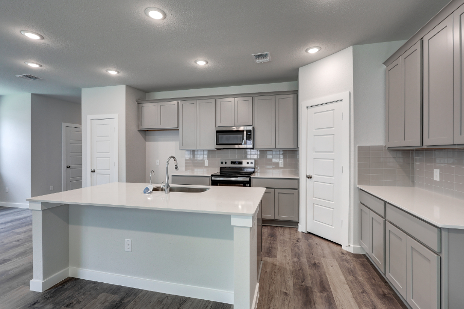 A kitchen with white cabinets.