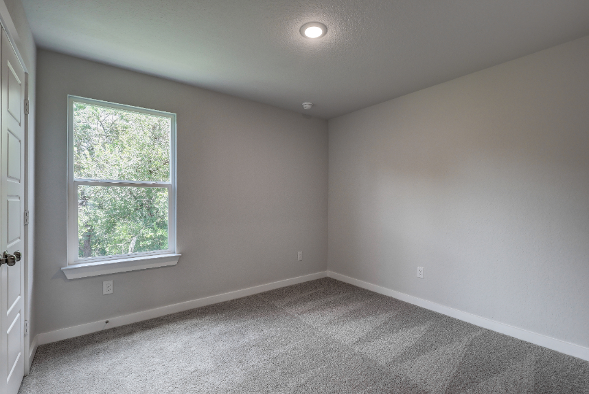 A room with a window and a carpet.