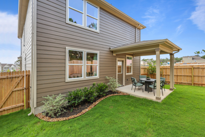 A house with a patio and a table and chairs in the front.