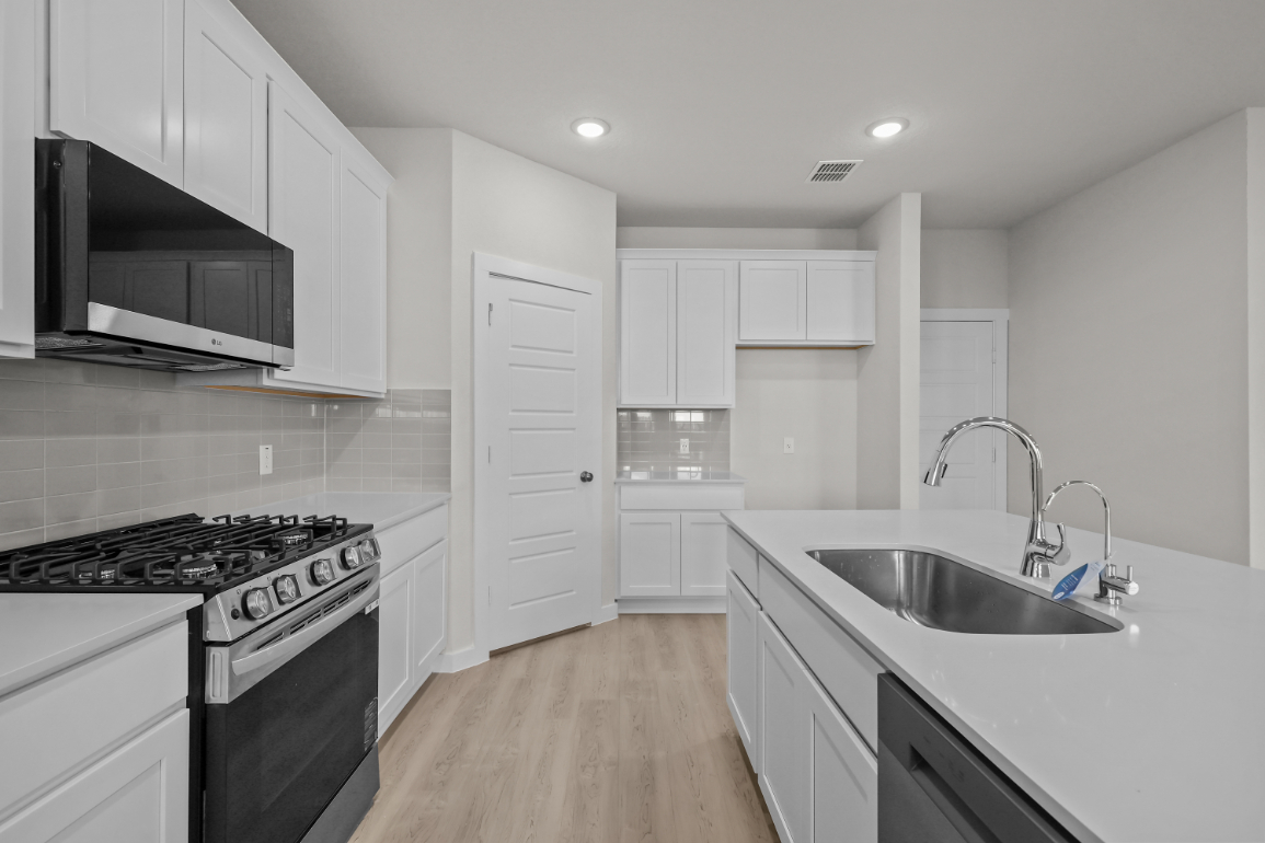A kitchen with white cabinets.