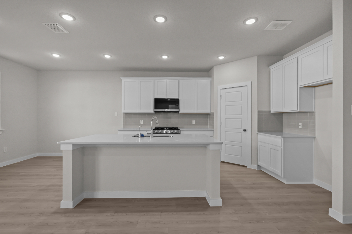 A kitchen with white cabinets.