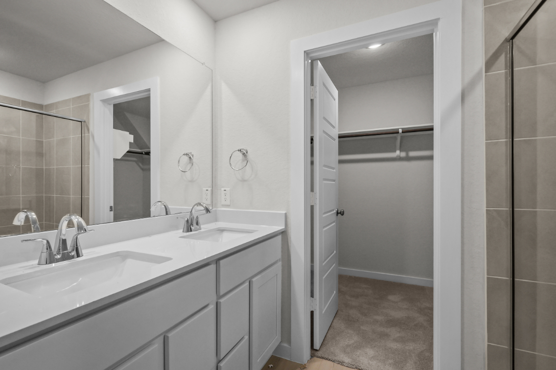 A bathroom with a sink and a shower unit.