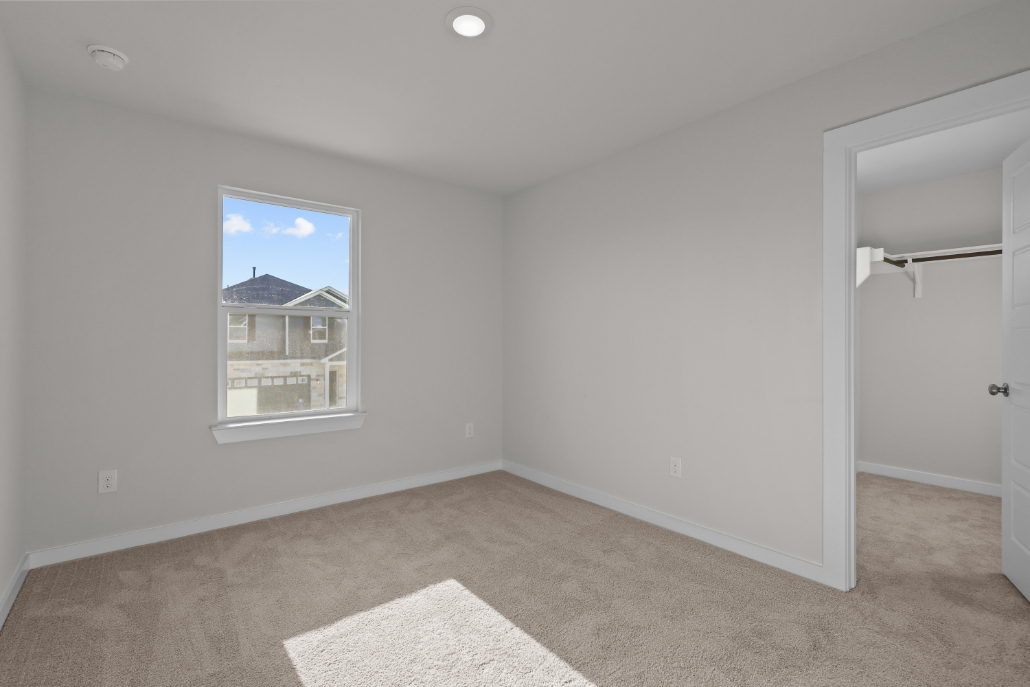 A room with a window and a rug.