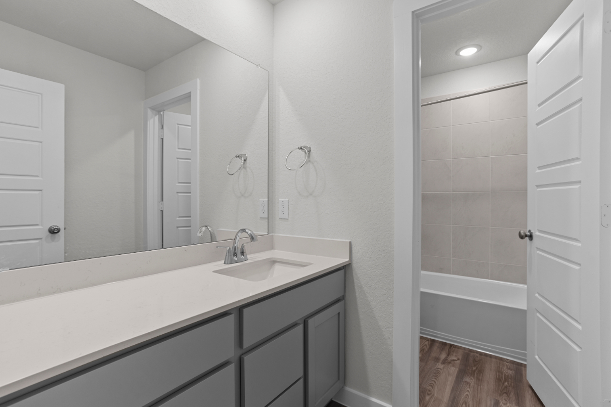 A bathroom with a sink and a shower unit.