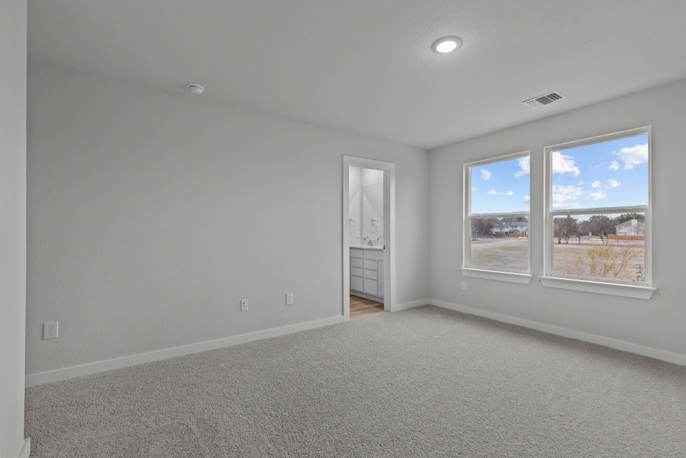 A room with a window and a door with a view of the city.