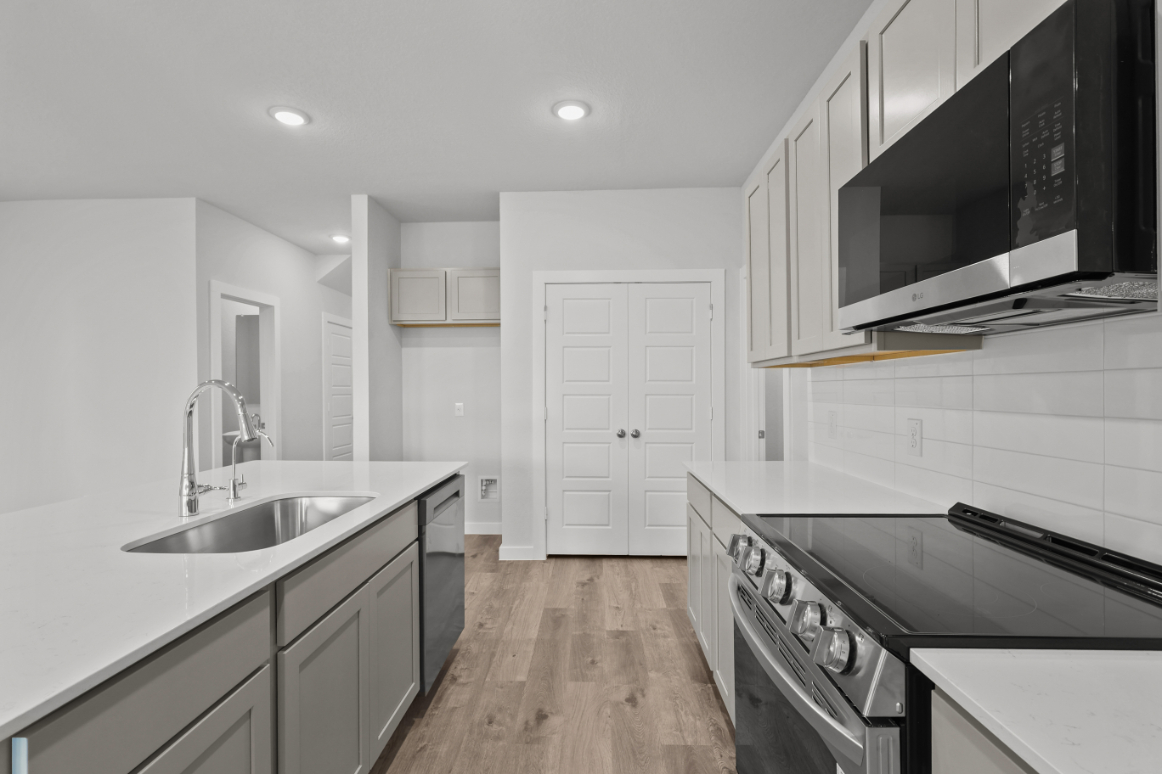 A kitchen with white cabinets.