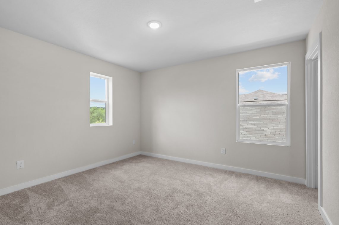 A room with a carpet and a window.