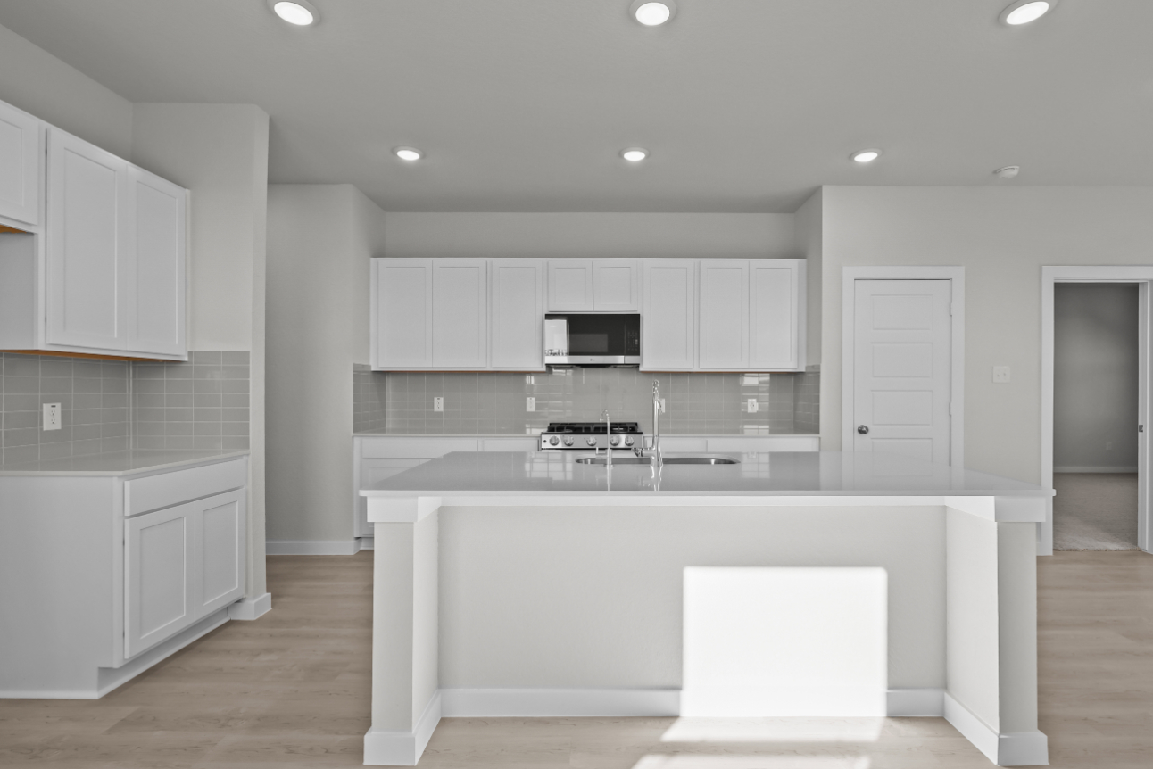 A kitchen with white cabinets.