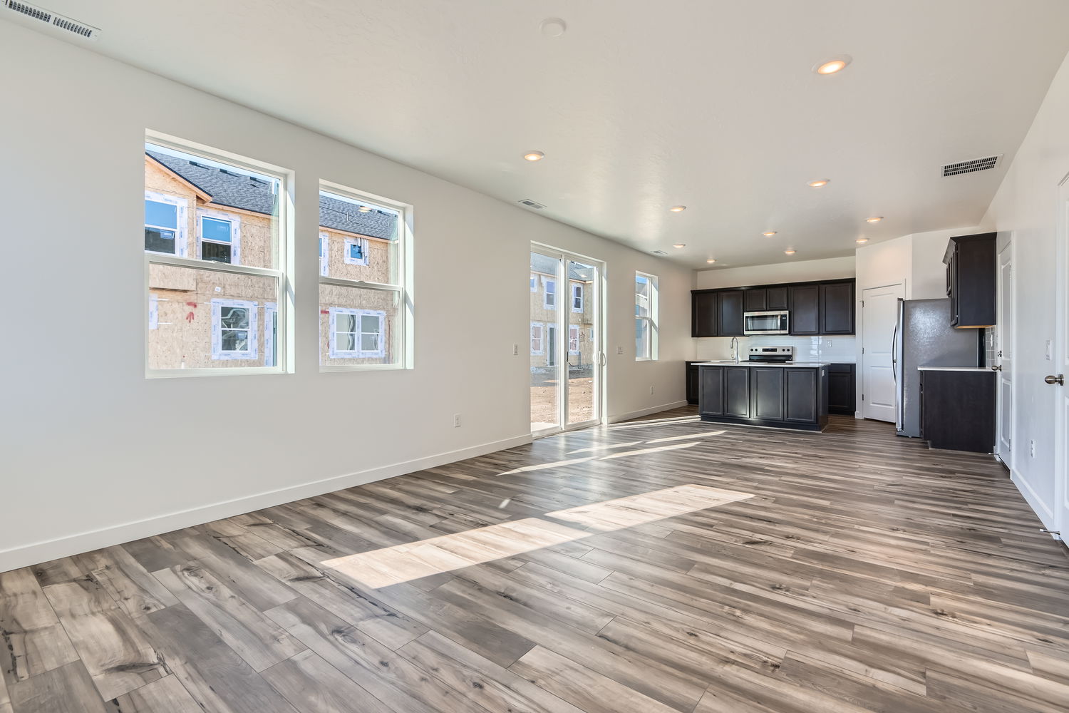 A large empty room with a wood floor and a wood floor.