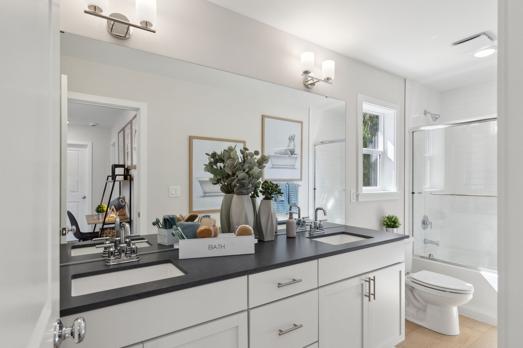 A bathroom with a sink toilet and mirror.
