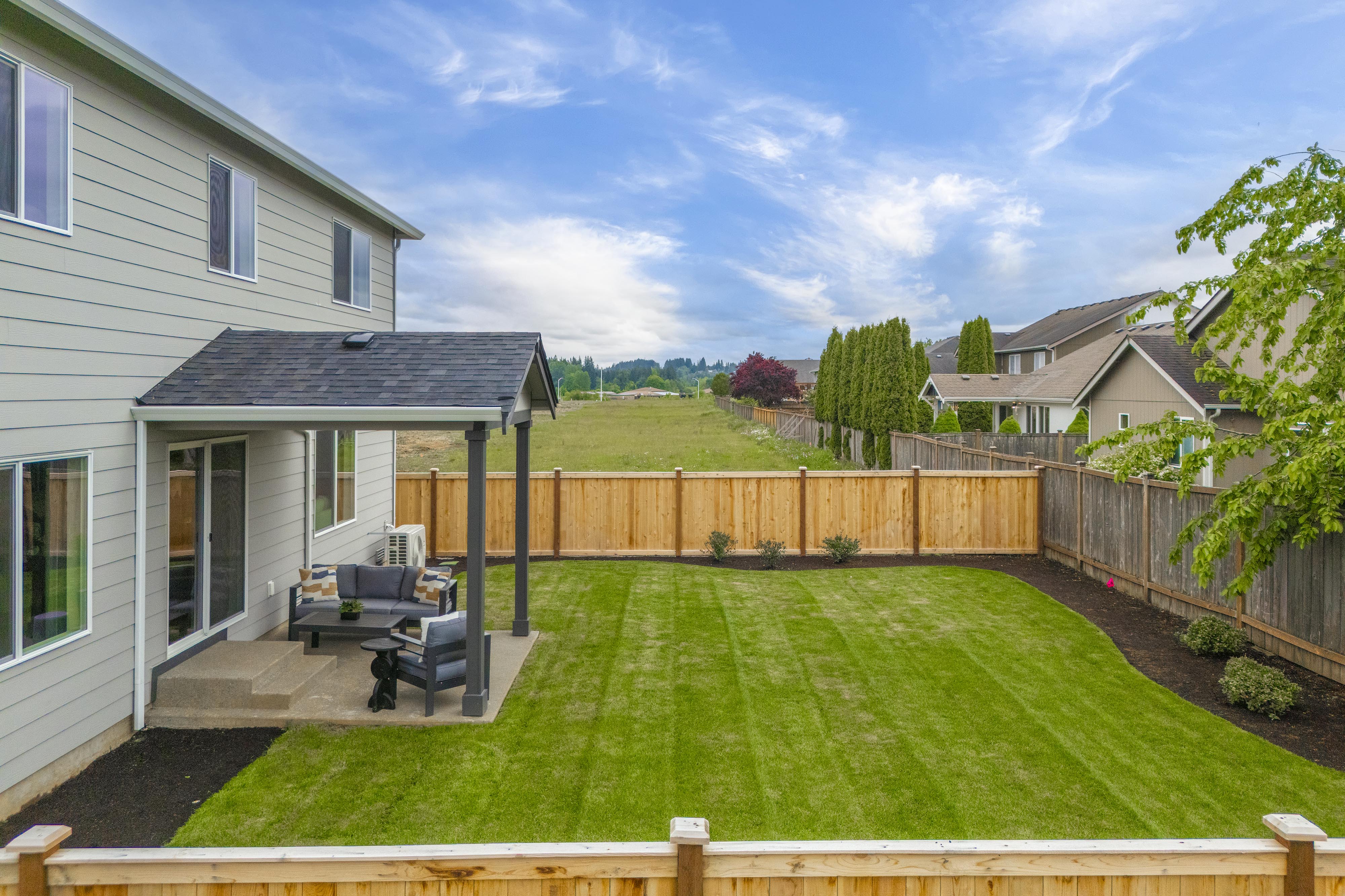 A backyard with a fence and lawn.