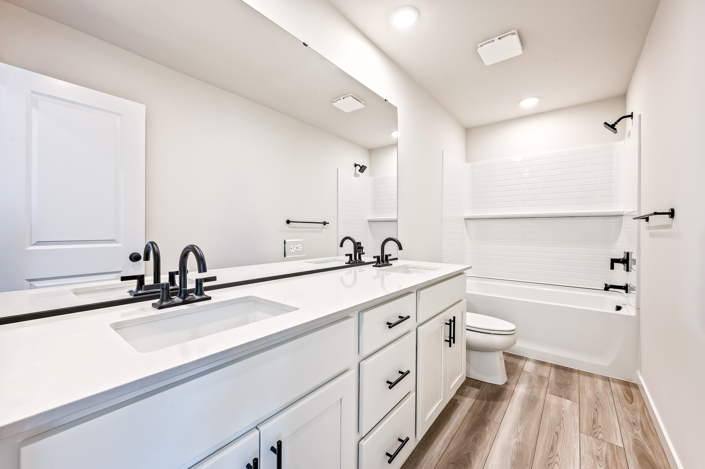 A bathroom with white cabinets.