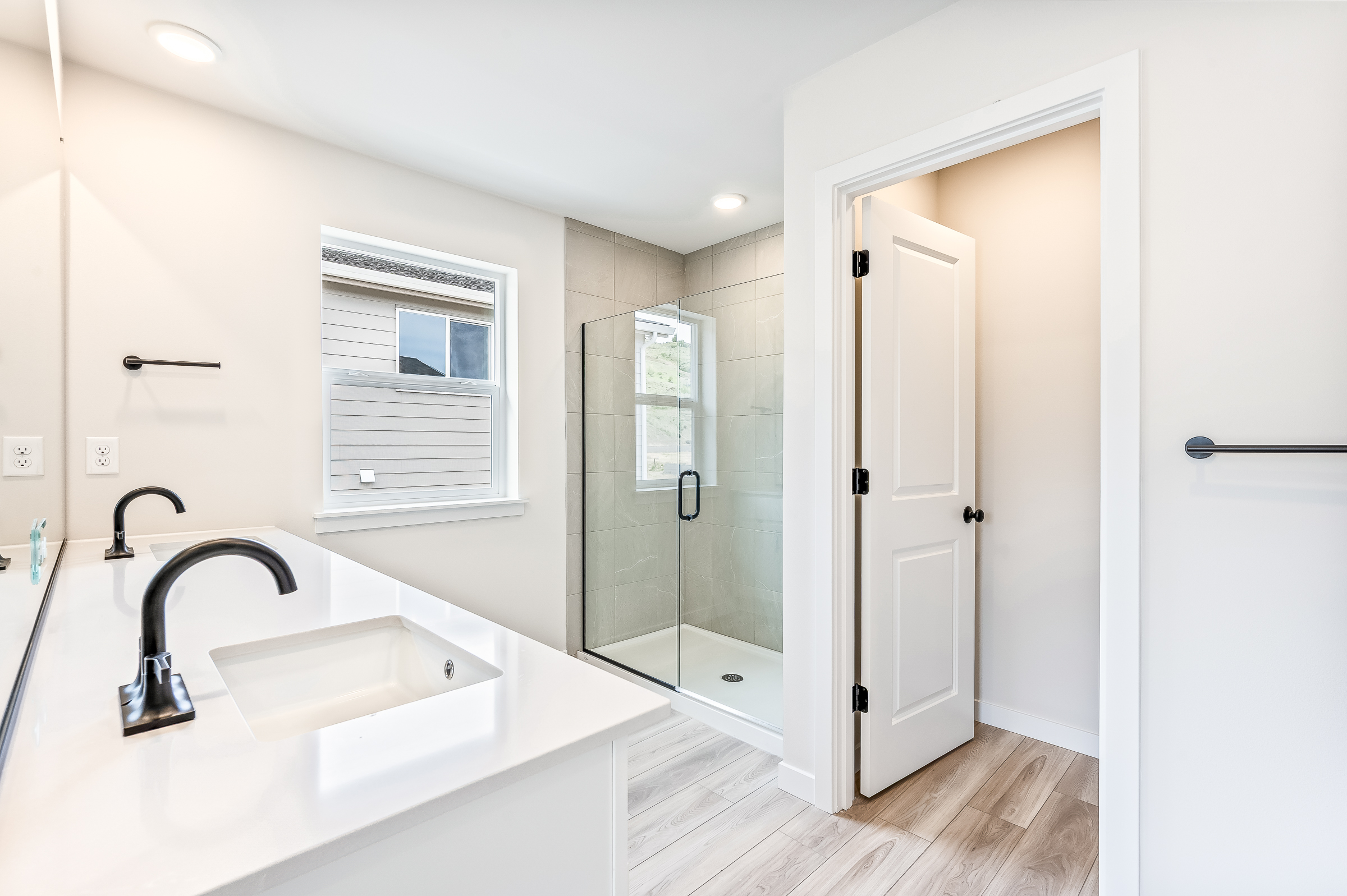 A bathroom with a sink and a shower unit.