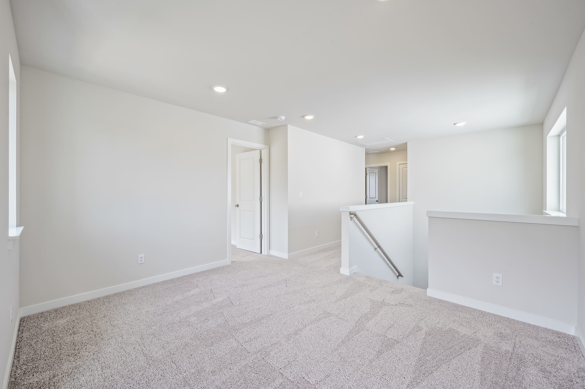 A room with a carpet and a white wall.