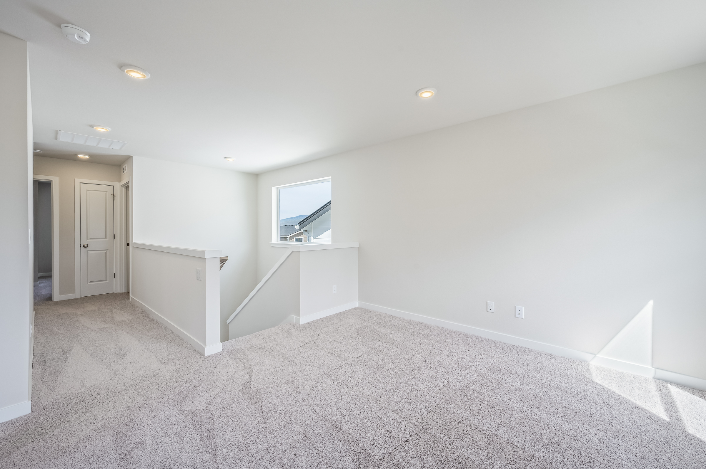 A room with a tv and white walls.