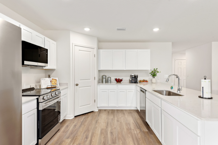 A kitchen with white cabinets.