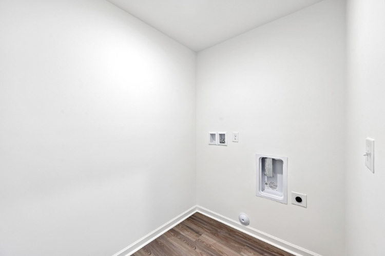 A white room with a wood floor.