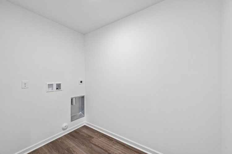 A white room with a wood floor.