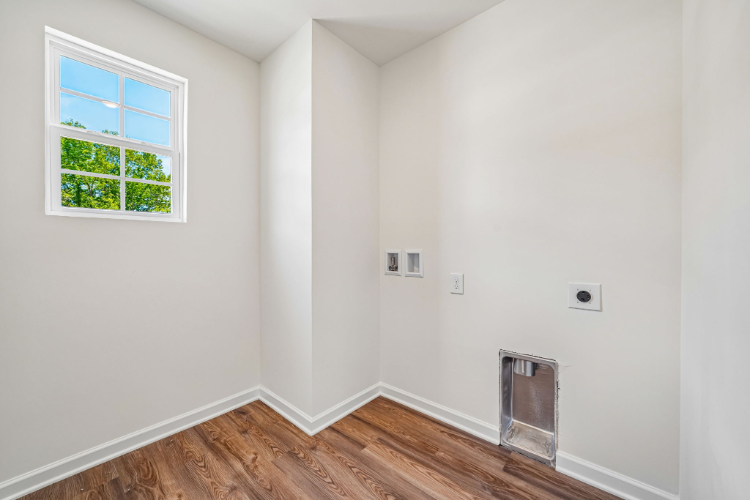 A room with a wood floor and a window.