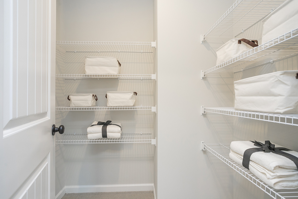 A white closet with white towels.