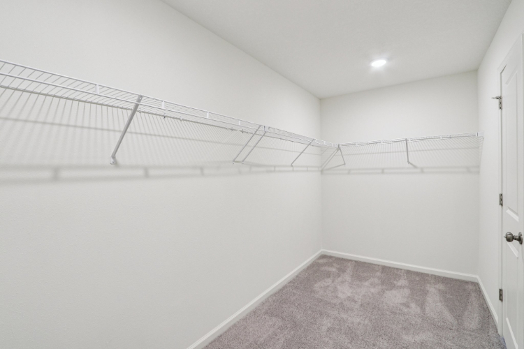 A white hallway with a metal railing.