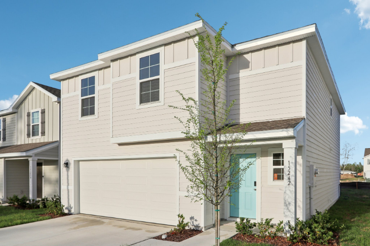 A white house with a tree in front of it.