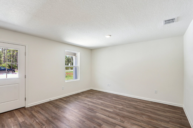 A room with a wood floor and windows.