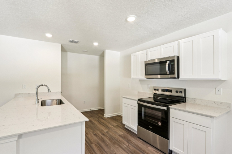 A kitchen with white cabinets.
