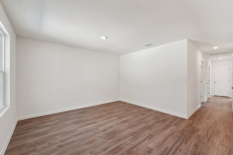 A room with a wood floor and white walls.