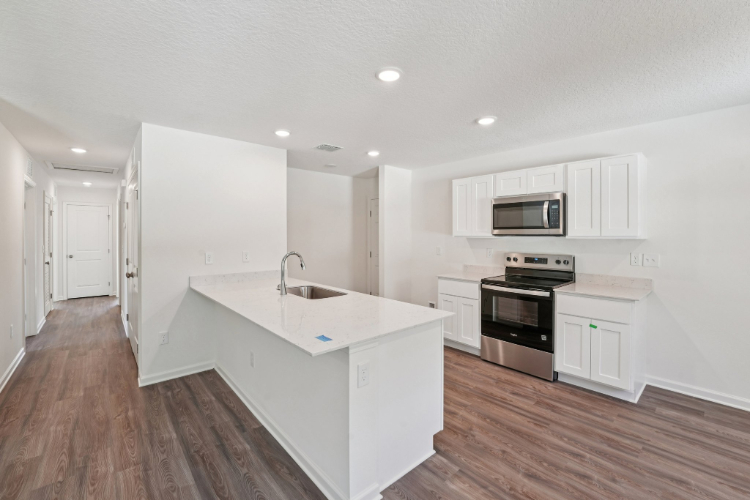 A kitchen with white cabinets.