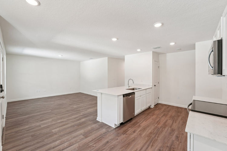 A kitchen with white cabinets.