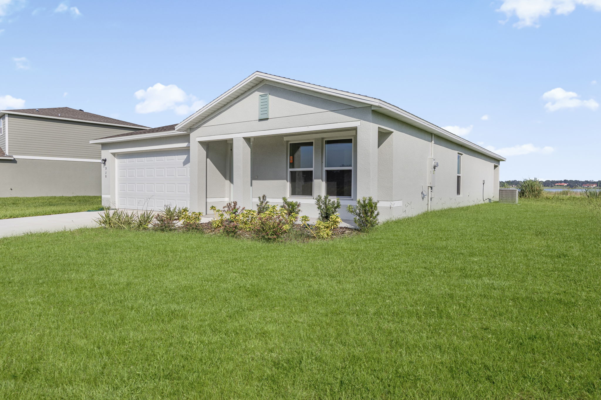 A house with a grass yard with Southfork Ranch in the background.