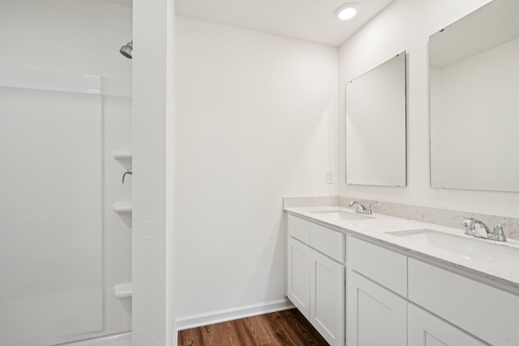 A bathroom with white cabinets.