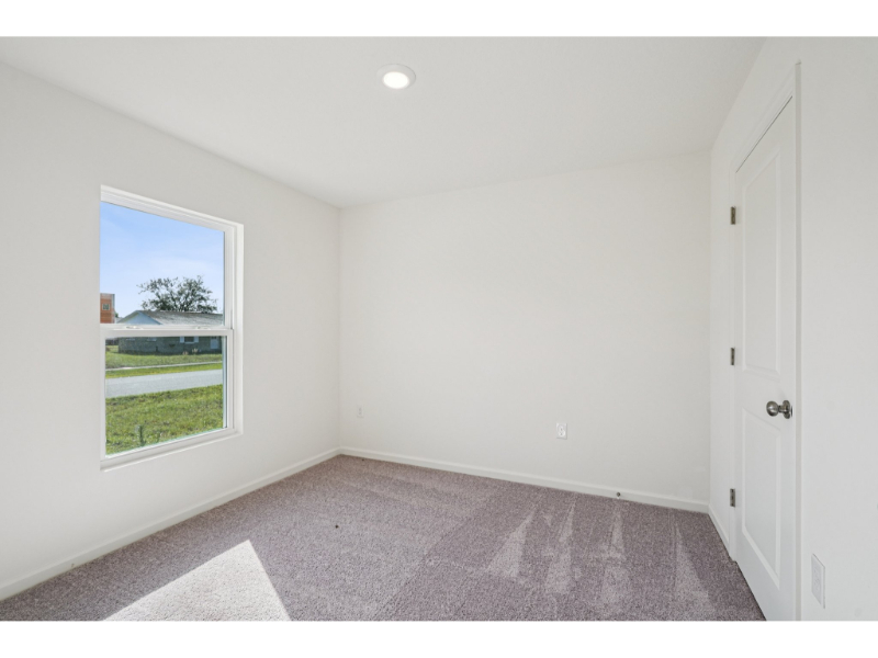 A room with a window and a carpet.
