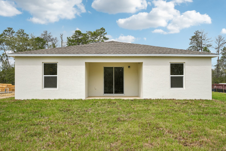 A white house with a grass yard.