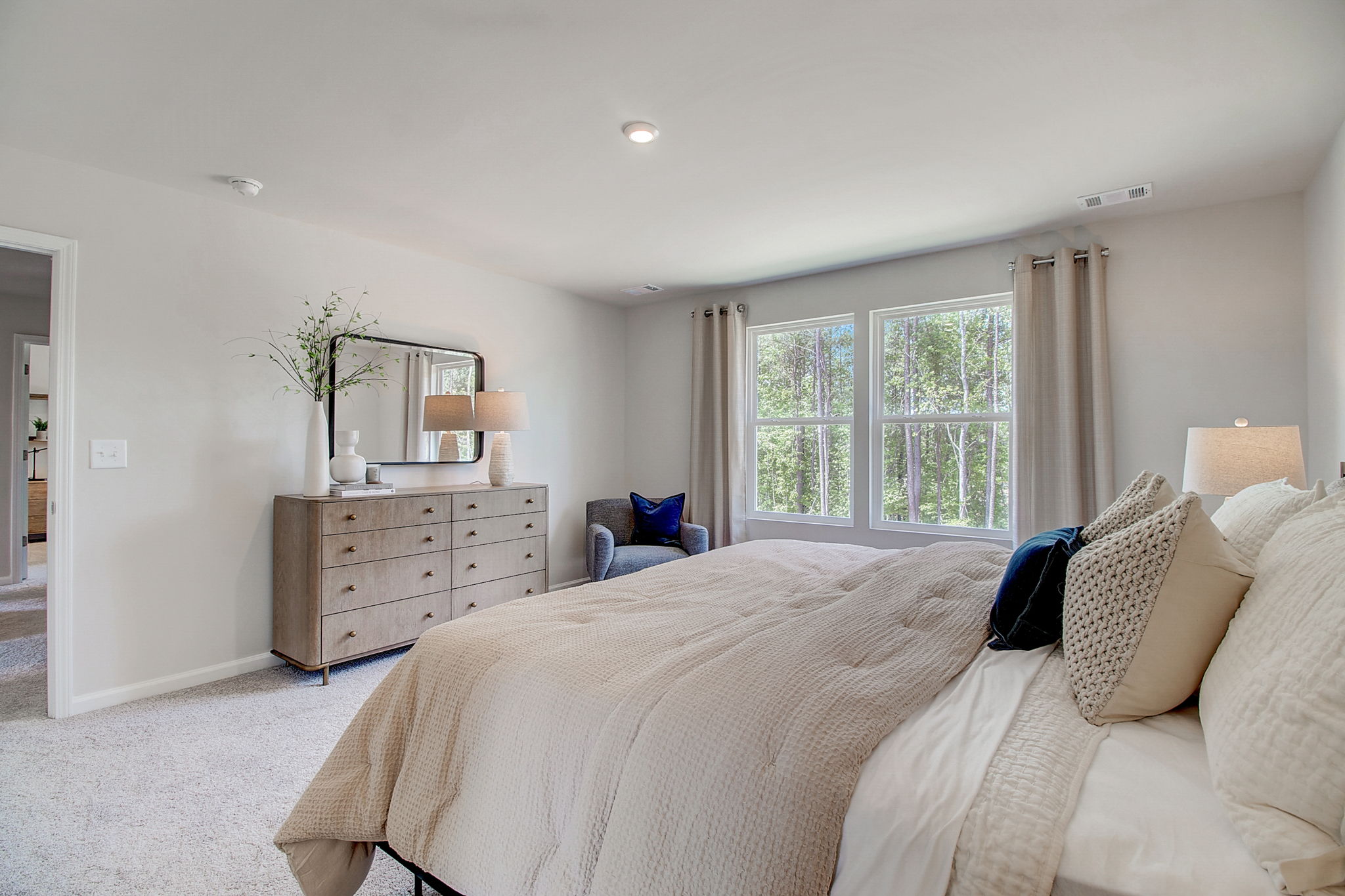 A large bedroom with a bed and a dresser.